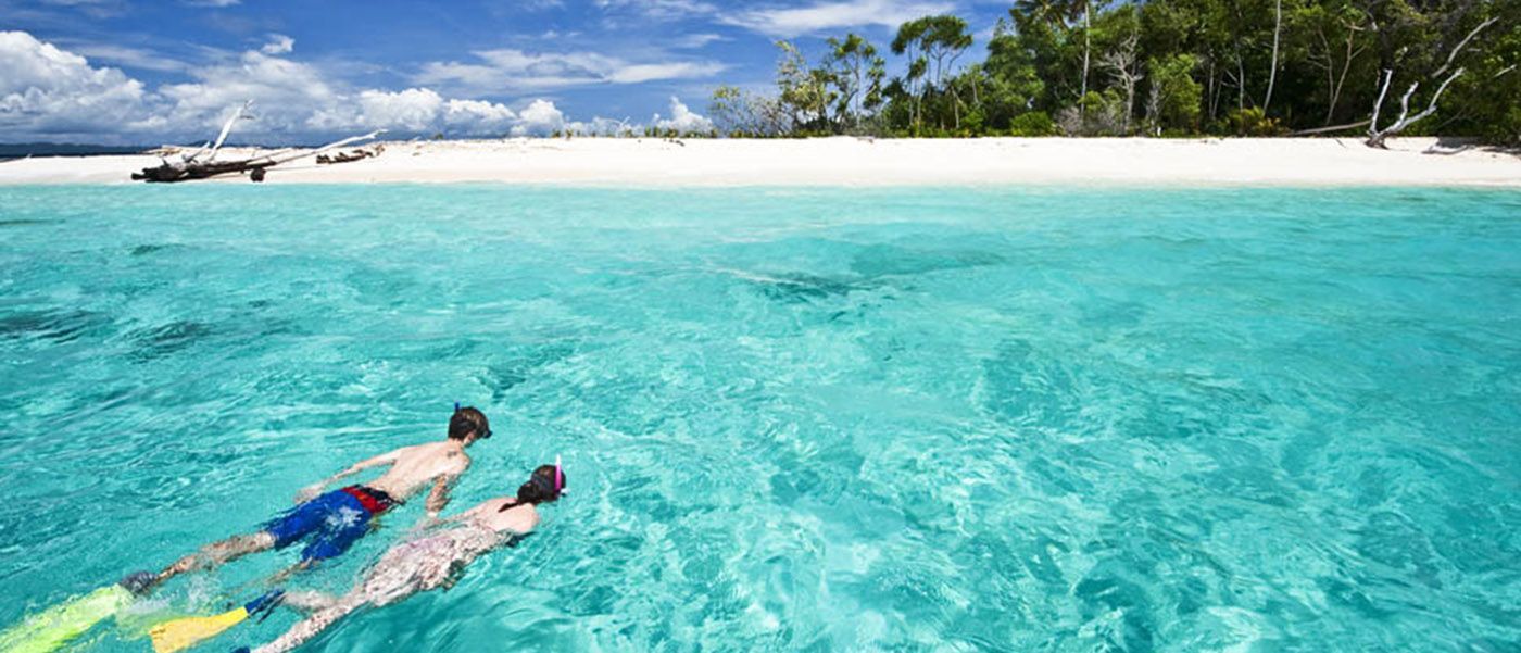 A couple snorkelling in clear blue water